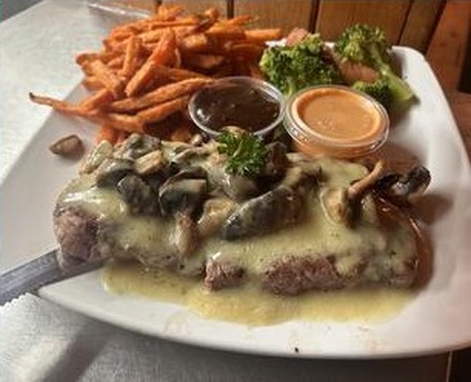 Une pièce de bœuf nappée d’une sauce crémeuse aux champignons, frites de patate douce et brocoli